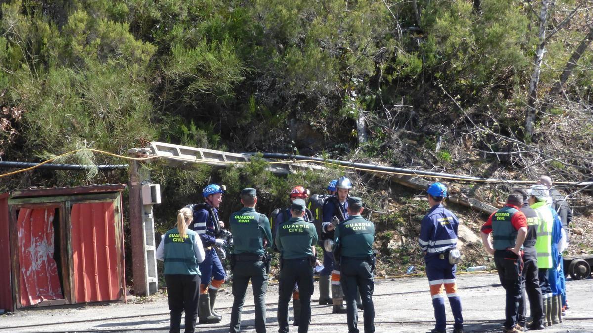 Agentes de la Guardia Civil conversan con integrantes de la Brigada de Salvamento Minero a unos metros de la bocamina tras el accidente.