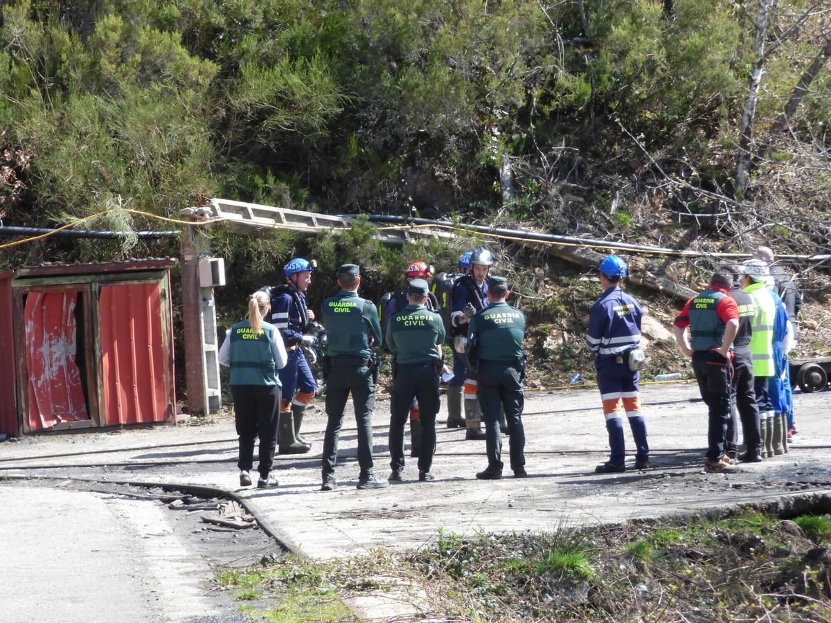 Agentes de la Guardia Civil conversan con integrantes de la Brigada de Salvamento Minero a unos metros de la bocamina de Cerredo.