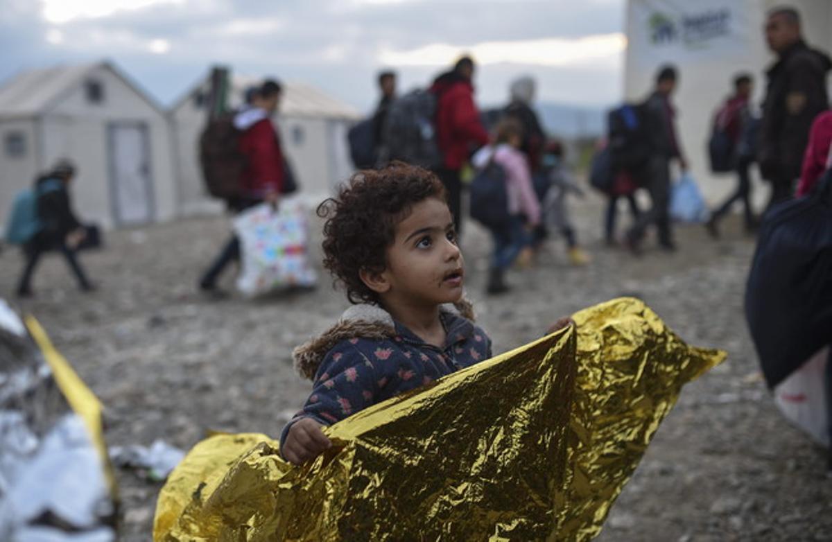 Una nena espera el permís per entrar al camp de registre avui després de travessar la frontera entre Grècia i Macedònia, a prop de la ciutat de Gevgelija.