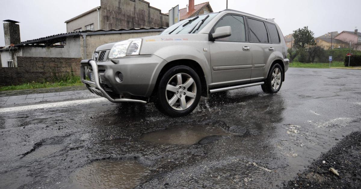 Un turismo evita un bache en la Rolda Leste. | BERNABÉ/JAVIER LALÍN