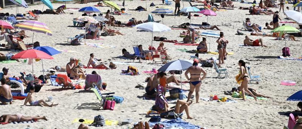 Bañistas ayer en la playa de Portocelo, en Marín. |   // RAFA VÁZQUEZ