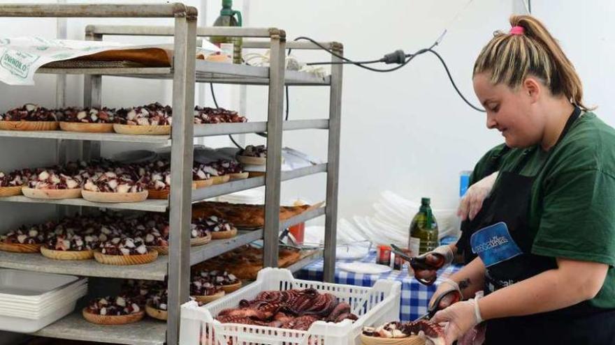 Una joven prepara raciones de pulpo, ayer, en el recinto de la fiesta gastronómica. // Gonzalo Núñez