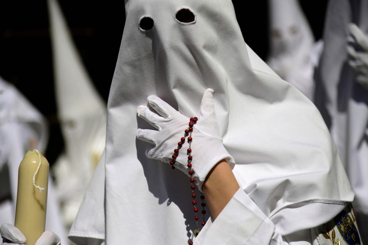 Penitentes de la hermandad de La Paz participan en la procesión del Domingo de Ramos en Sevilla