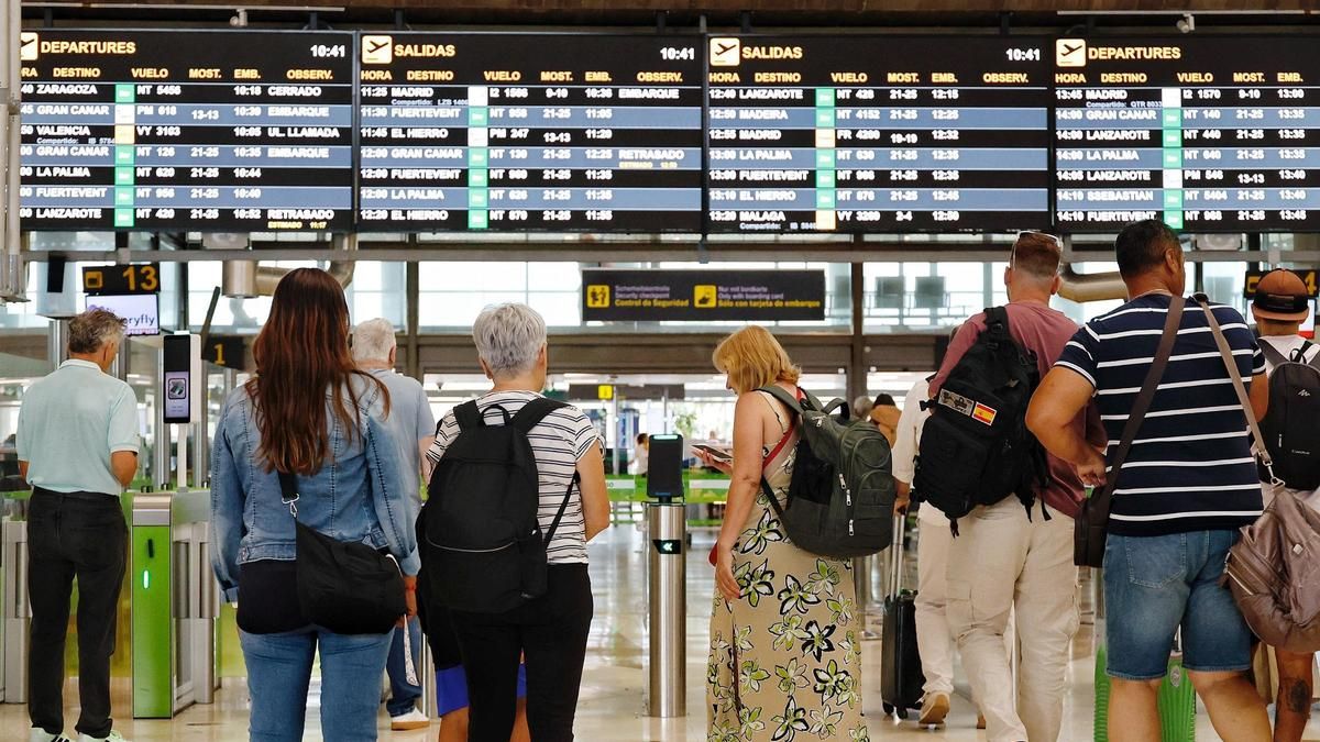 Pasajeros frente a los paneles informativos del Aeropuerto Tenerife Norte-Ciudad de La Laguna.