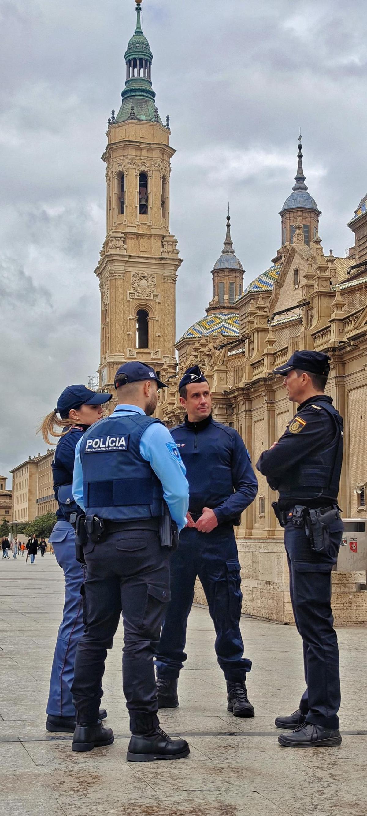 Agentes internacionales con un policía nacional en la plaza del Pilar.