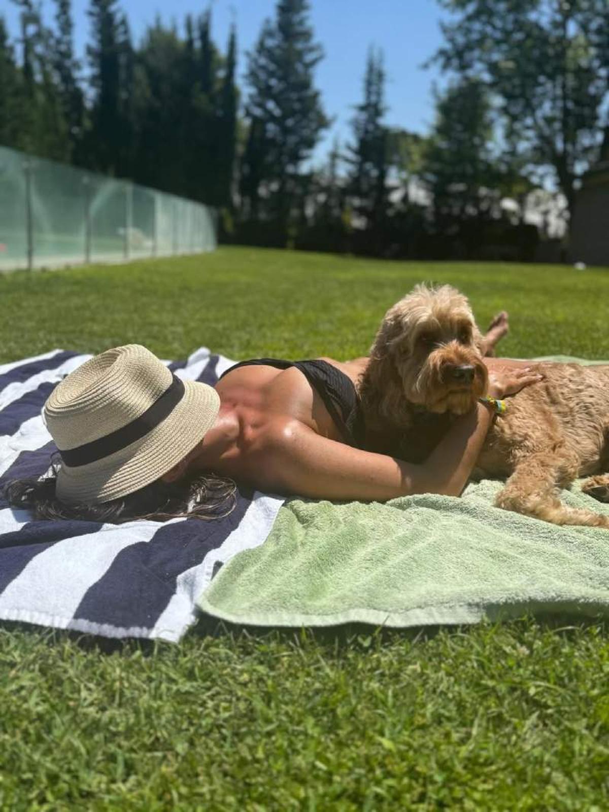 Malú descansa junto a su perro cerquita de la piscina