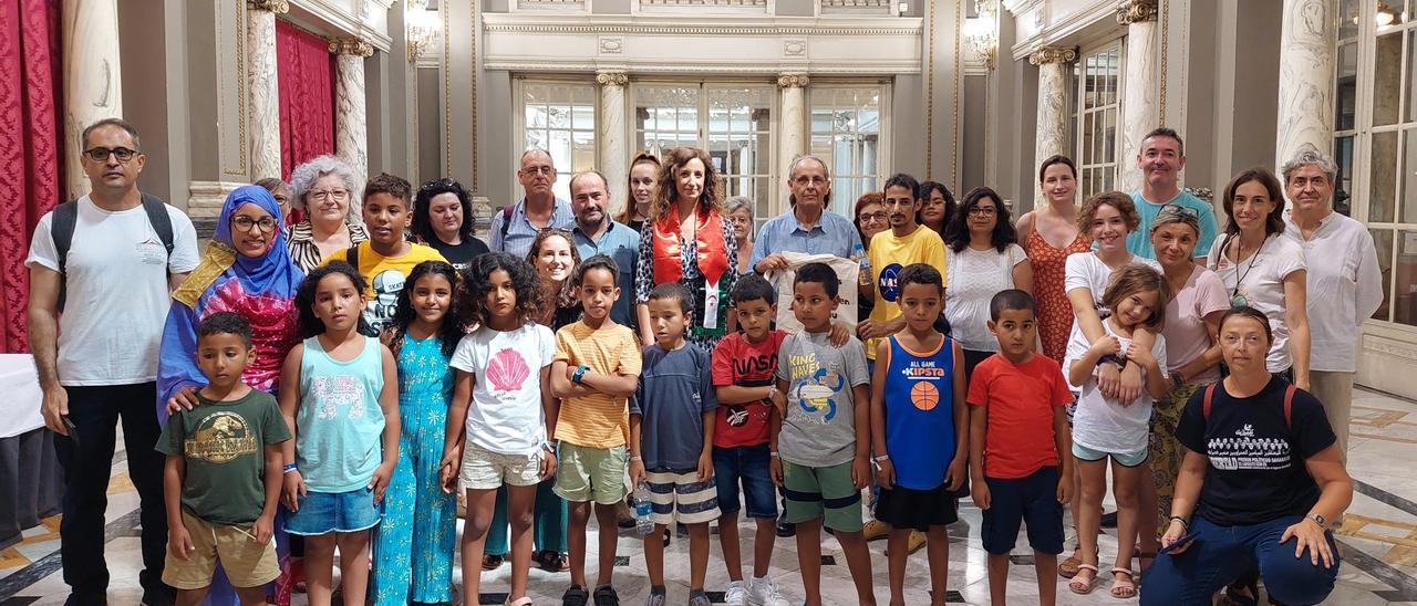 Menores saharauis, junto a sus familias de acogida valencianas y la concejala de Cooperación, Maite Ibáñez, en el Ayuntamiento de València.