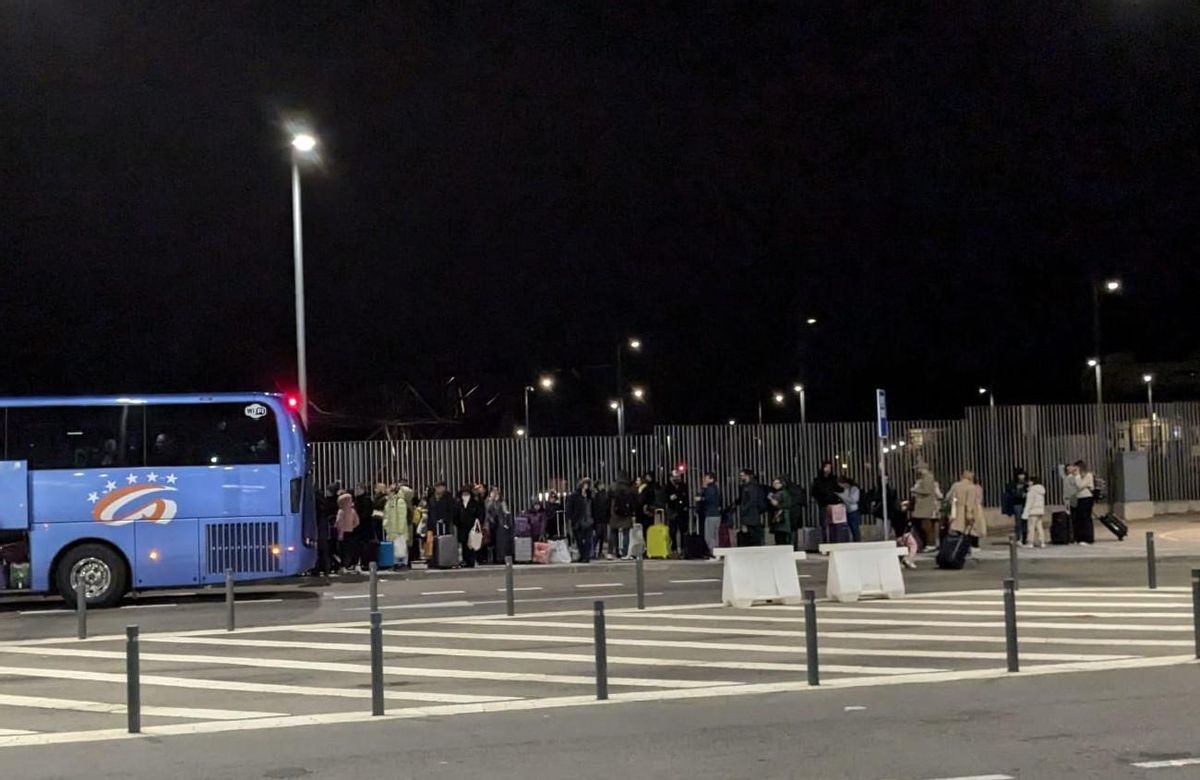 Los pasajeros del Alvia averiado esta tarde en León hacen cola para subir a un autoicar que les lleve a Asturias.