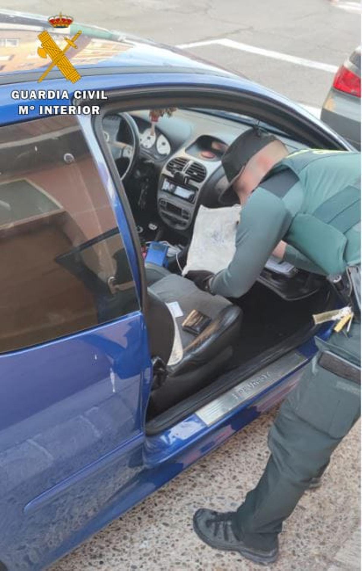 Un agente de la Guardia Civil inspeccionando el coche de uno de los detenidos