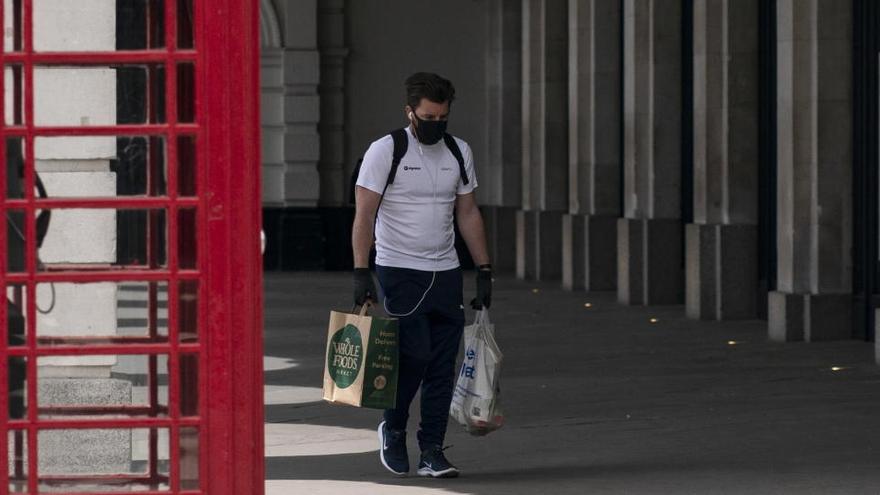 Un hombre regresa de comprar en el centro de Londres.