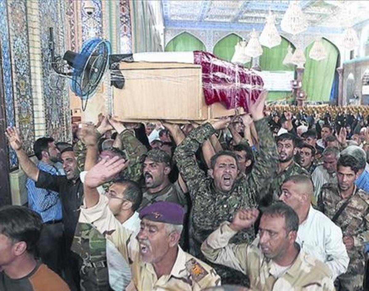 Unos iraquís portan el ataúd de un experto en explosivos en Karbala.