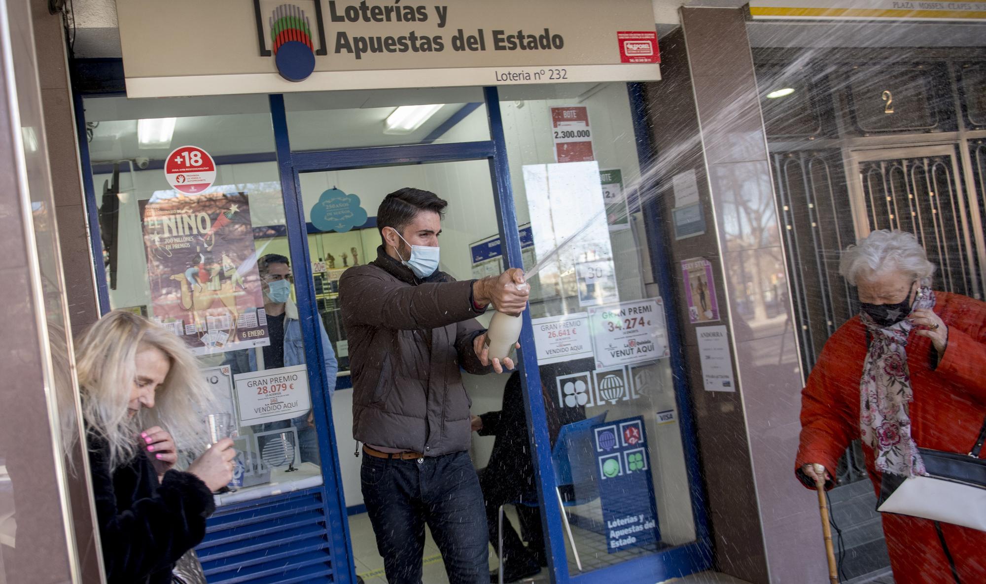 Daniel Zapata, propietario de la ad. de lotería 232 en Sant Andreu, celebrando con cava la venta del segundo premio de la lotería del Niño.