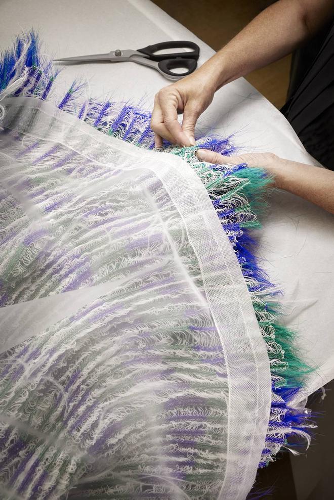 Detalle de los artesanos de Louis Vuitton cosiendo las plumas del vestido de Cynthia Erivo en los premios Emmy