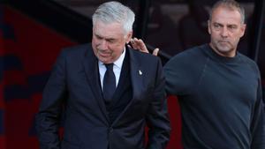 Carlo Ancelotti y Hansi Flick se saludan durante el último Barça-Real Madrid en Montjuïc.