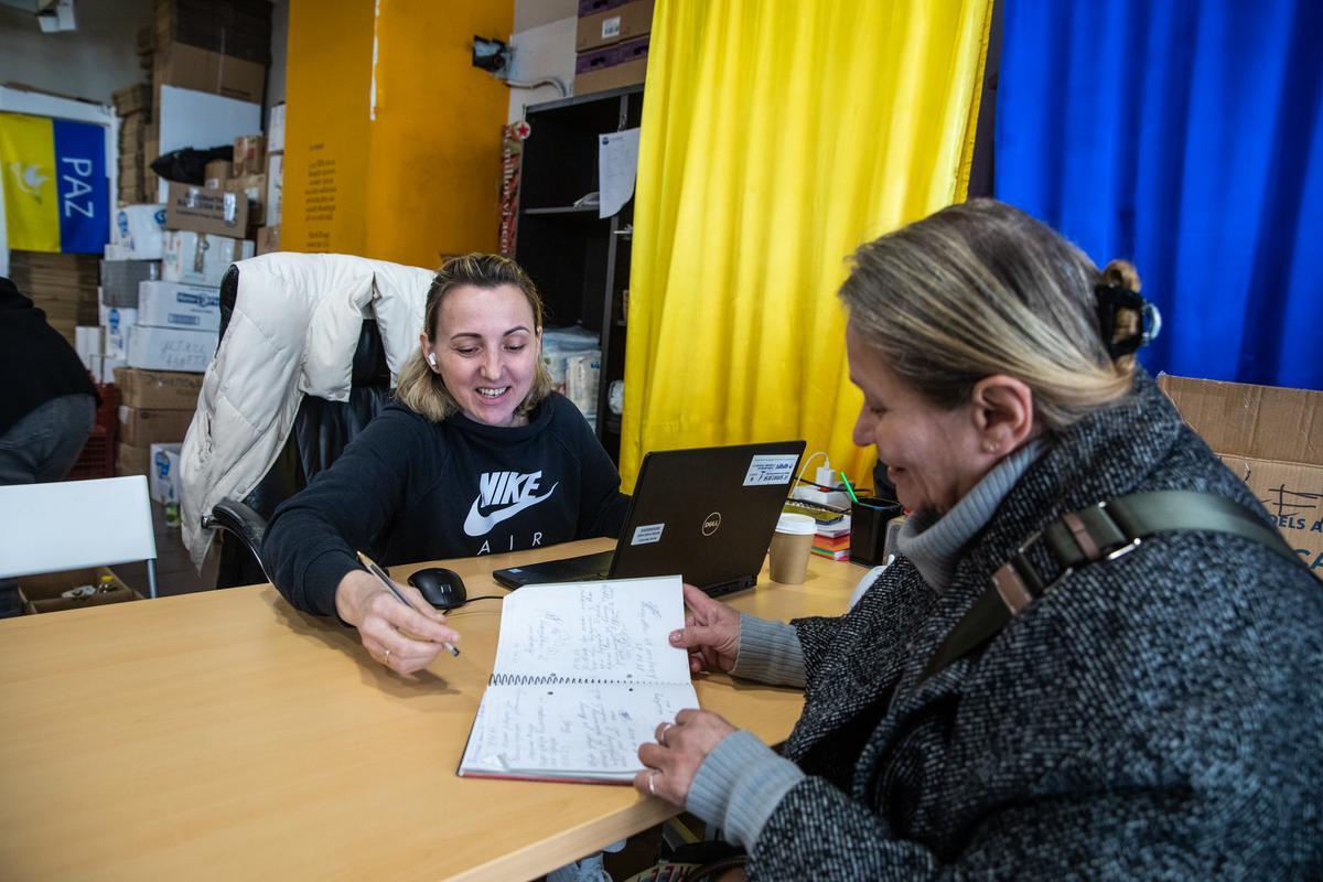 Kataryna Hladysh atiende una familia en el centro de distribución de ayuda humanitaria para los refugiados ucranianos de Barcelona, el pasado lunes.