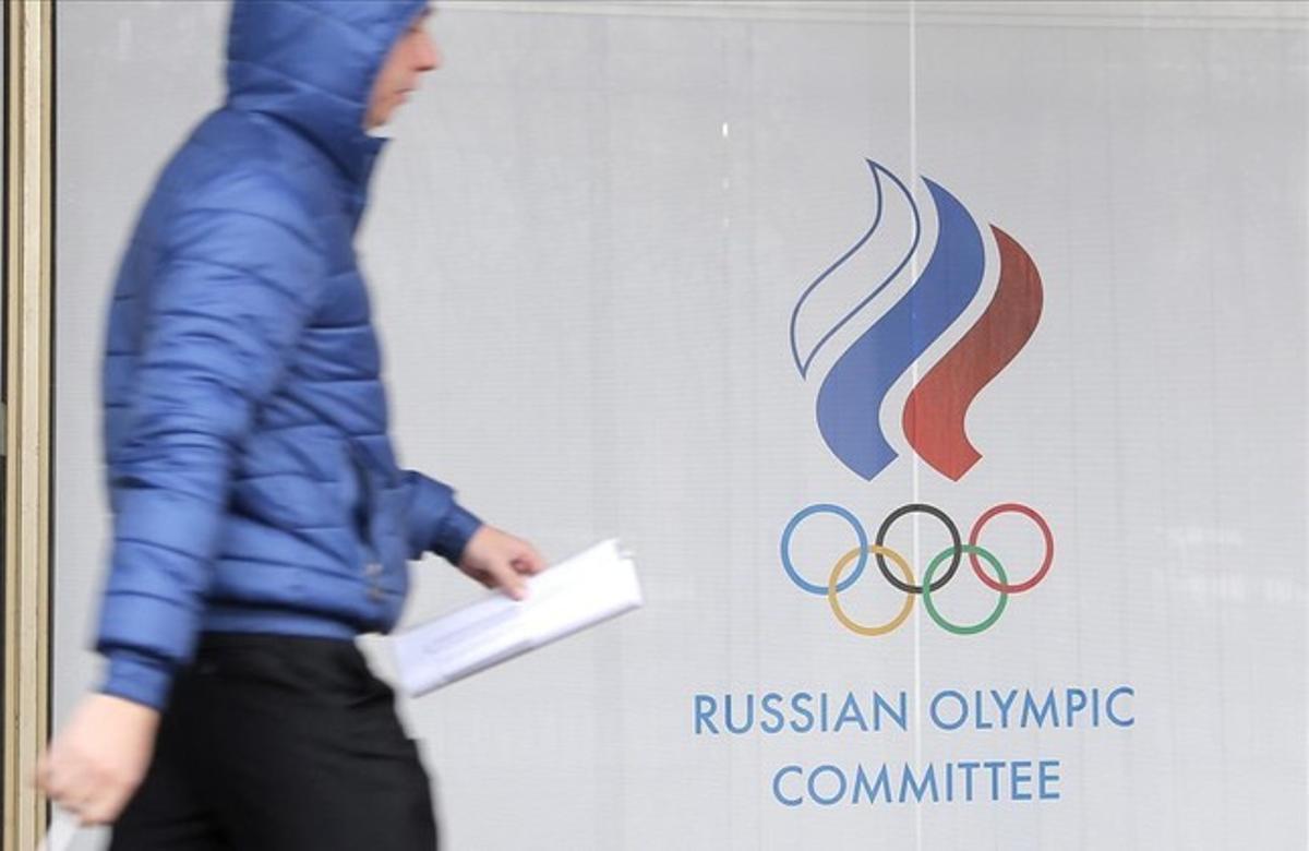 Una persona pasa junto a la sede del Comité Olímpico Ruso.