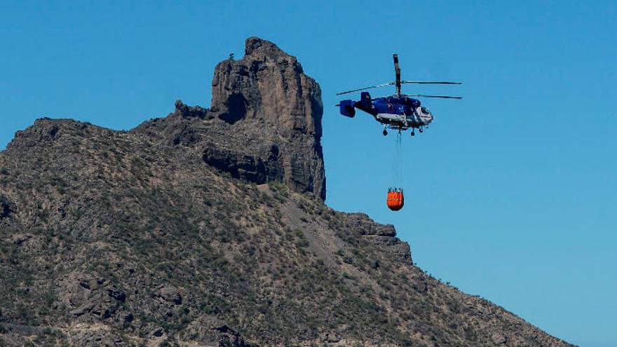 Un helicóptero Kamov que ha operado durante el incendio, cargando la bolsa de agua, con el Bentayga al fondo.