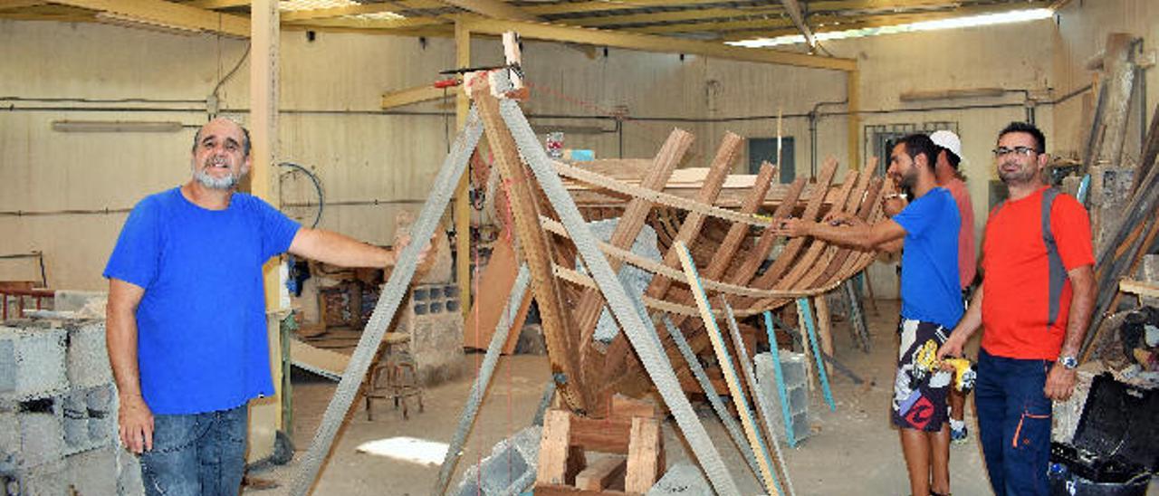 Agustín Jordán, el pasado viernes, junto a la lancha en construcción y sus alumnos Carlos Martín, Manuel Espinosa y Francisco Rodríguez, en el taller de la Escuela de Arte Pancho Lasso, en Arrecife.