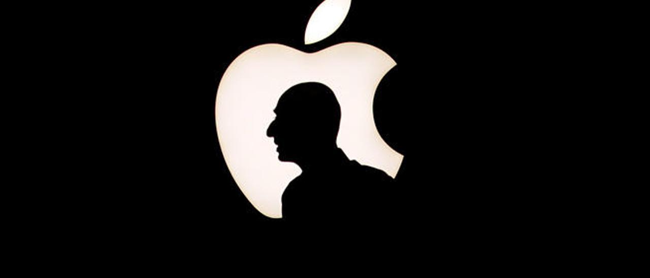 Un hombre camina ante el logo de Apple // BECK DIEFENBACH