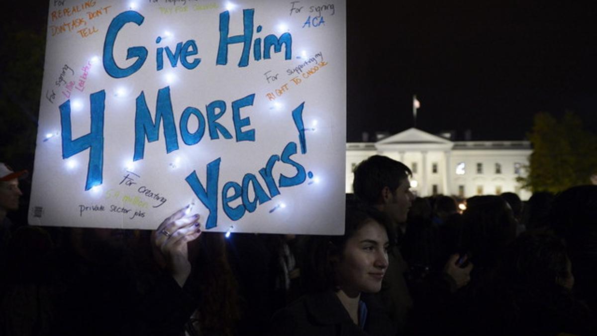 Una simpatizante de Obama sostiene una pancarta en la que se lee 'Dale cuatro años más', esta madrugada, frente a la Casa Blanca, donde cientos de personas han celebrado la victoria demócrata.