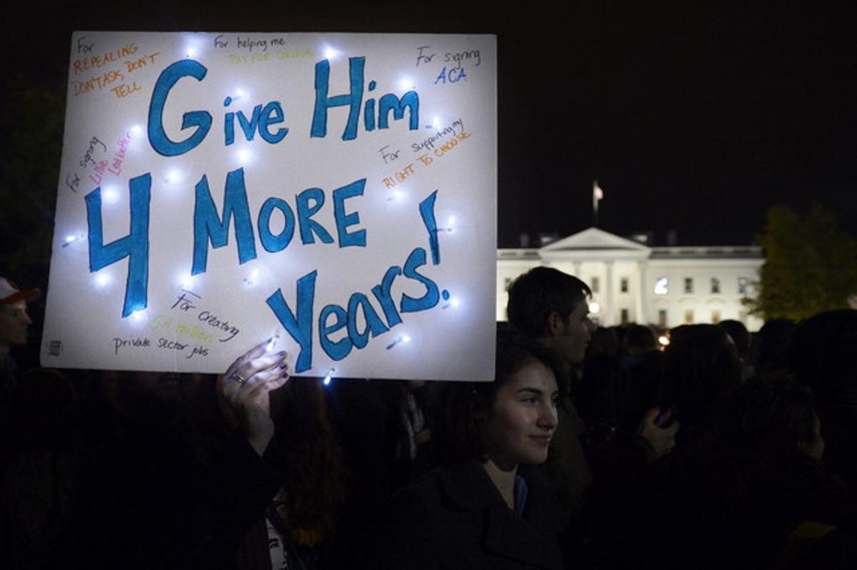 Una simpatitzant d’Obama sosté una pancarta en què es llegeix ’Dóna-li quatre anys més’, aquesta matinada, davant de la Casa Blanca, on centenars de persones han celebrat la victòria demòcrata.