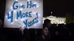 Una simpatitzant d’Obama sosté una pancarta en què es llegeix ’Dóna-li quatre anys més’, aquesta matinada, davant de la Casa Blanca, on centenars de persones han celebrat la victòria demòcrata.