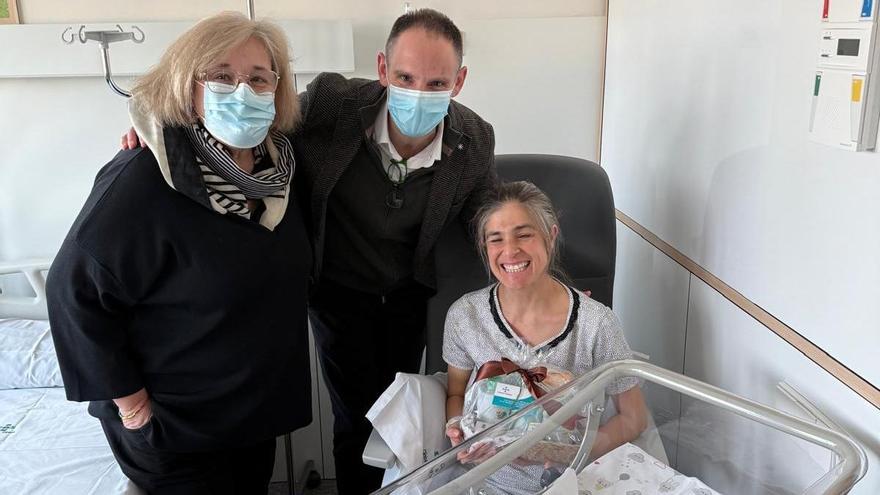 La mare, Anabel, rebent un obsequi de mans del gerent de Clínica Girona, Miquel Grabulosa, i la directora assistencial del centre, doctora Eva Palau.