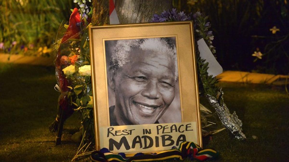Un retrato de Mandela junto a velas y flores, en Johannesburgo.