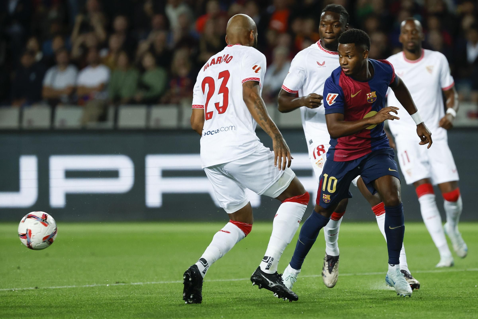 Barcelona&#039;s Ansu Fati, front right, duels for the ball with Sevilla&#039;s Marcao during a Spanish La Liga soccer match between Barcelona and Sevilla at the Olimpic Lluis Companys stadium in Barcelona, Spain, Sunday, Oct. 20, 2024. (AP Photo/Joan Monfort)