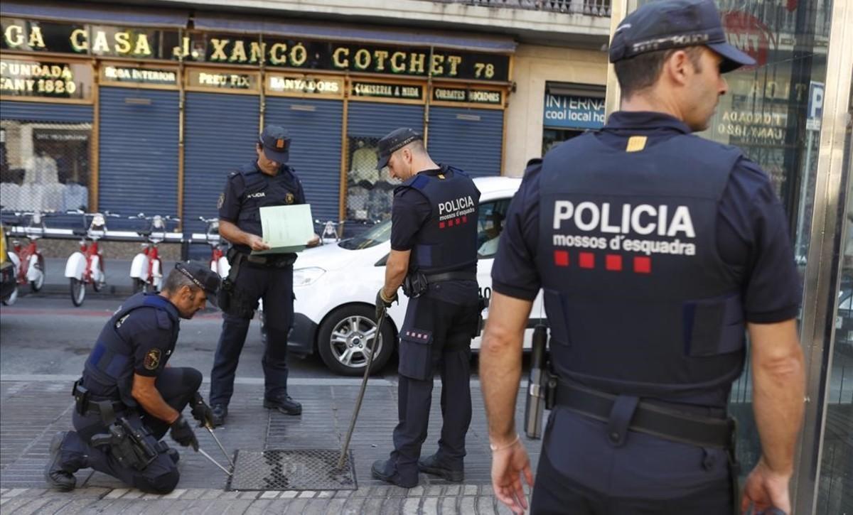 Los Mossos revisan una alcantarilla en la Rambla.