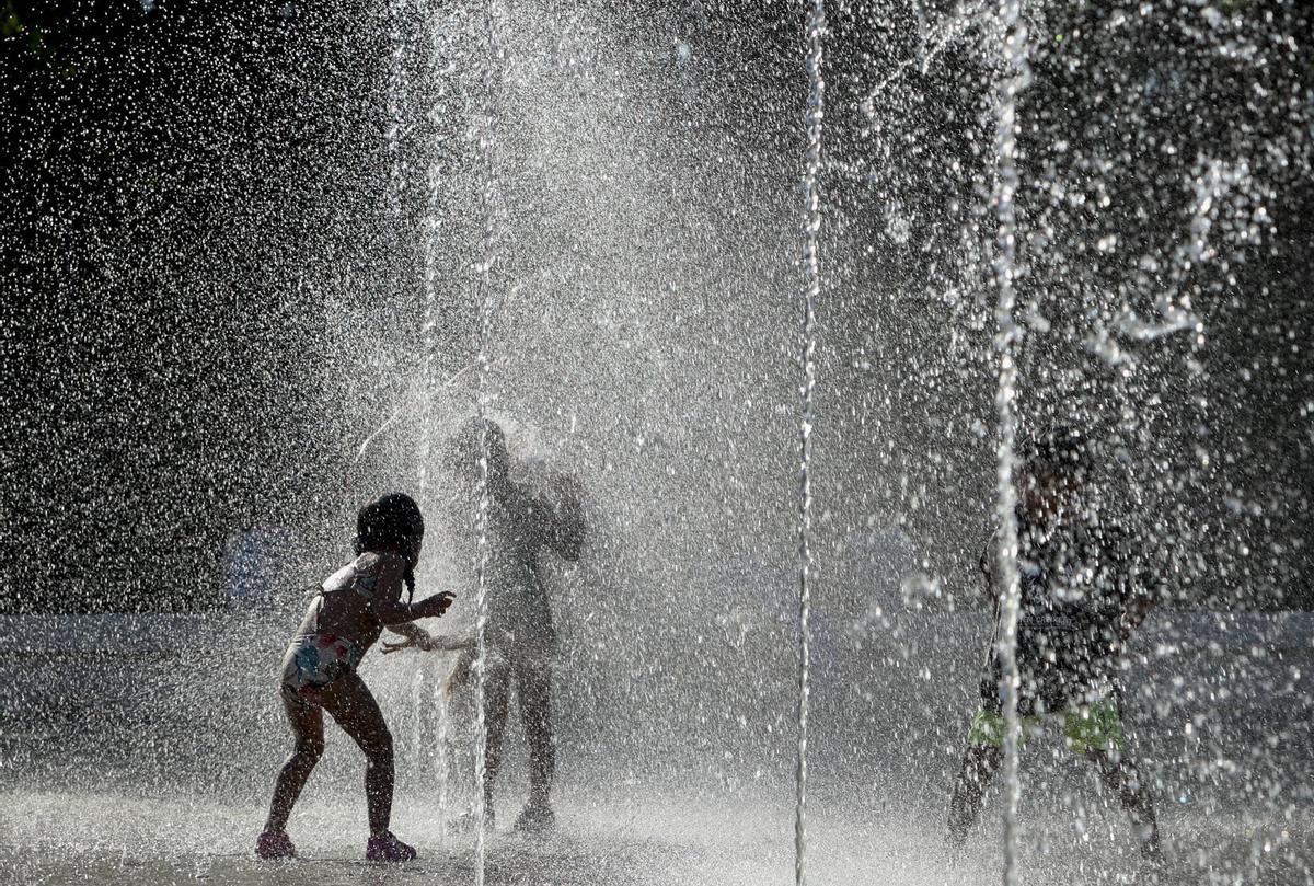 Niñas refrescándose en las fuentes del Parc Central de València.