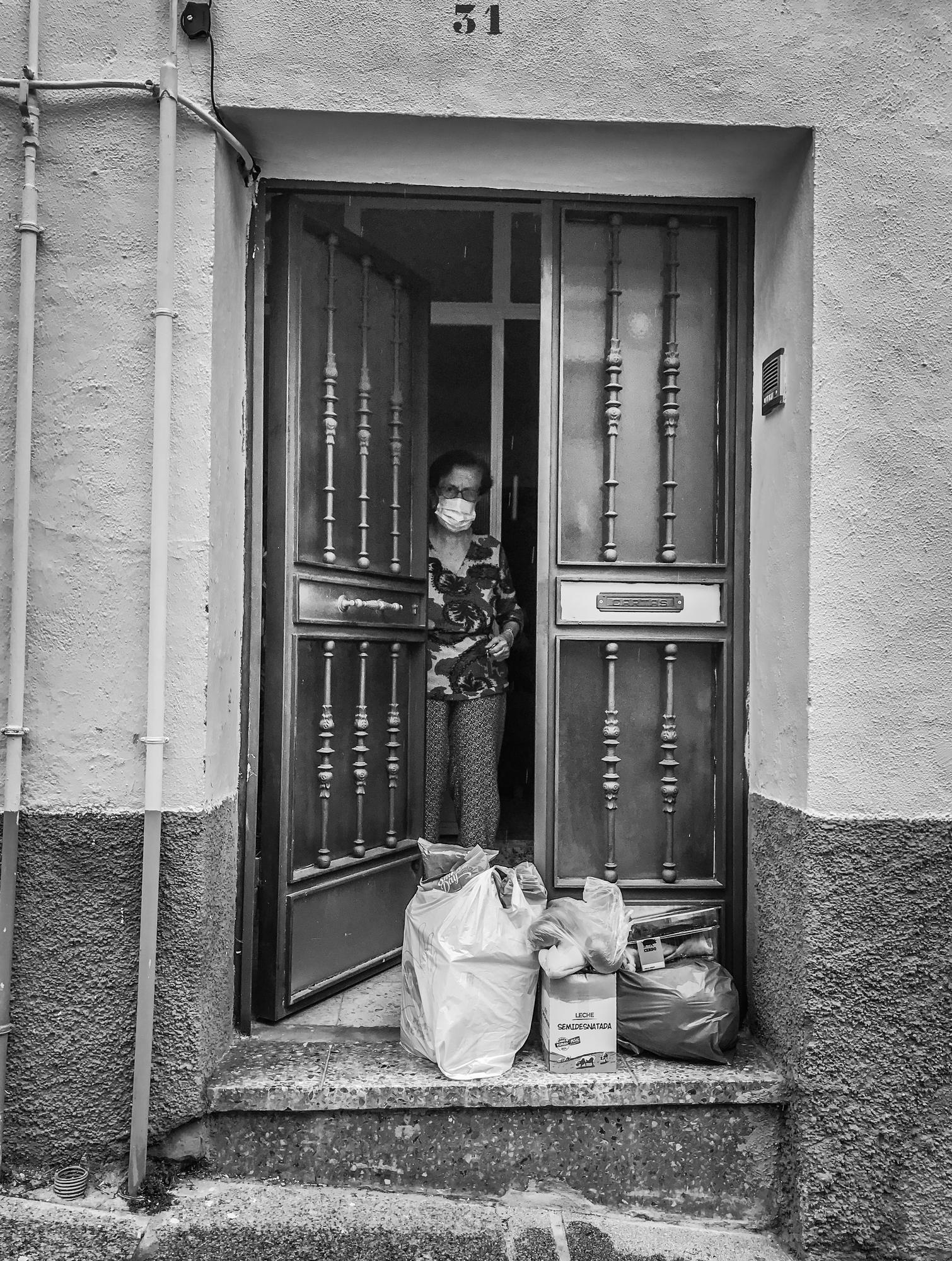 Una mujer mira la compra que le ha dejado en la puerta su hijo, el autor de la foto. / JOSÉ GÓMEZ