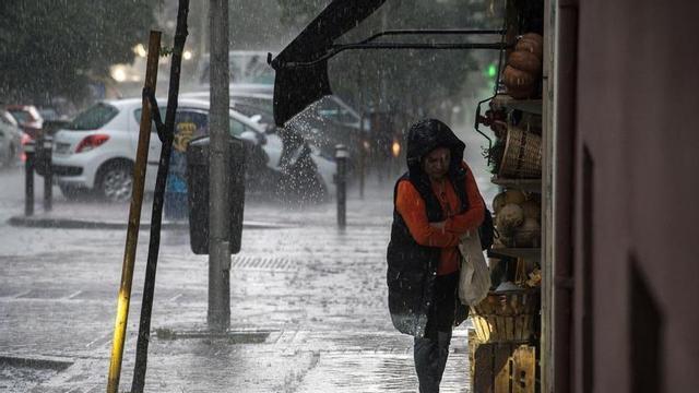 Una dona amb paraigua sota la pluja.