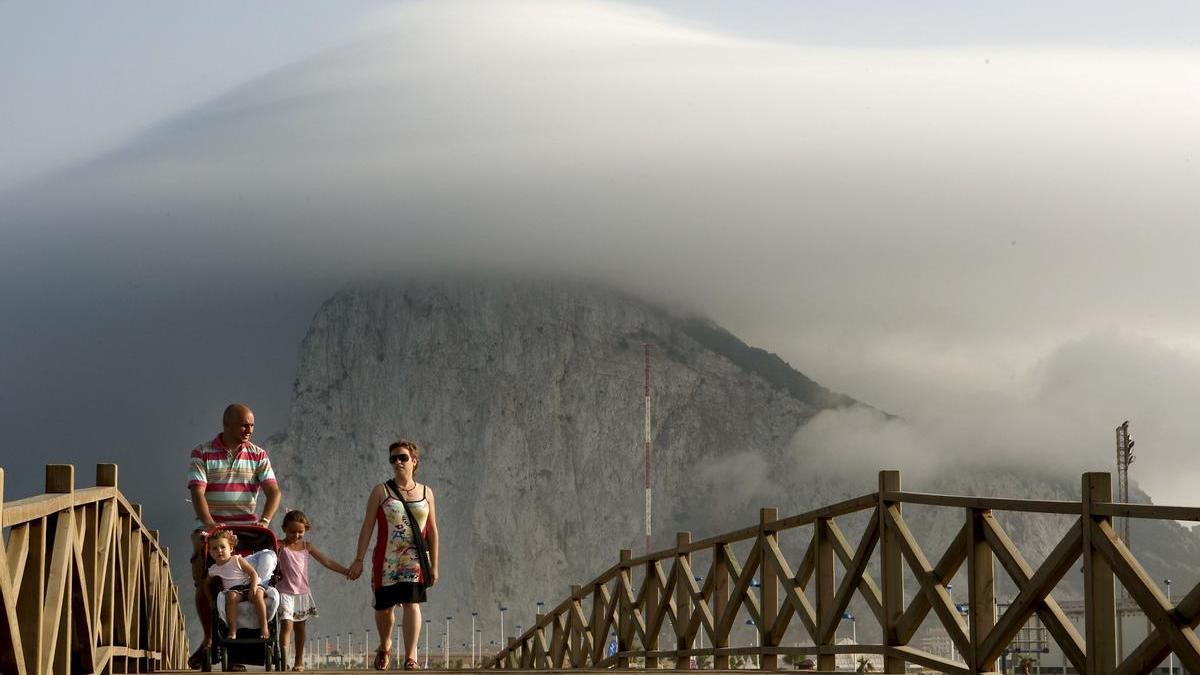 Una familia de La Línea de la Concepción (Cádiz) pasea frente al peñón de Gibraltar.