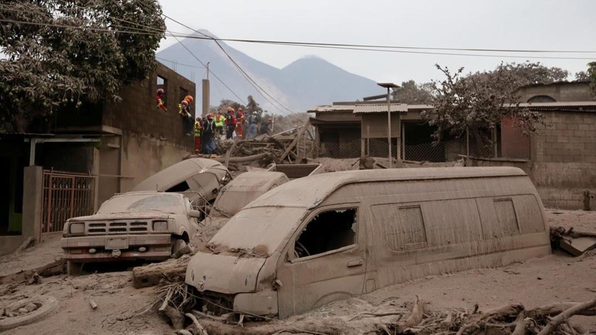 Bomberos y personal de rescate inspecciona los destrozos causados por el volcán de Fuego en Escuintla, Guatemala.