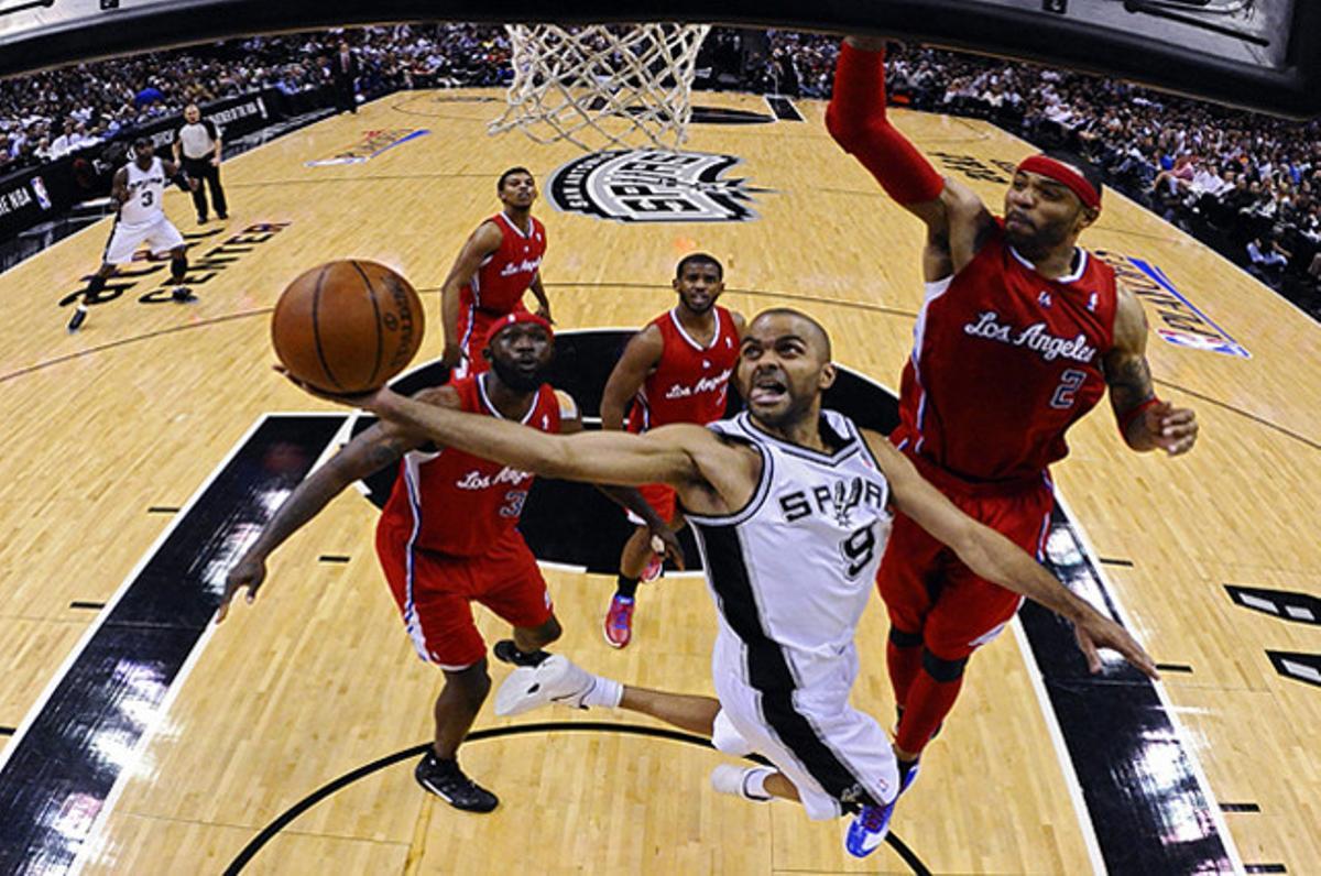 El jugador dels Spurs Tony Parker (centre) encistella davant la marca de Kenyon Martin (dreta), dels Clippers, durant un partit de les semifinals de la Conferència Oest de la NBA, a Texas (EUA).