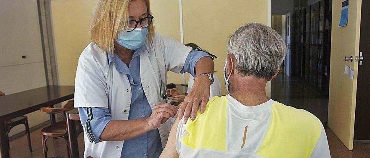 Una infermera vacuna contra la grip un usuari a Girona.