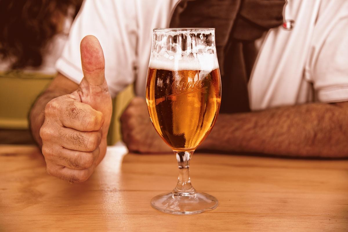 Un hombre en un bar con una cerveza