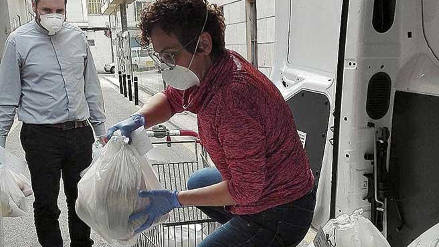 Voluntarios de CÃ ritas reparten comida a domicilio.