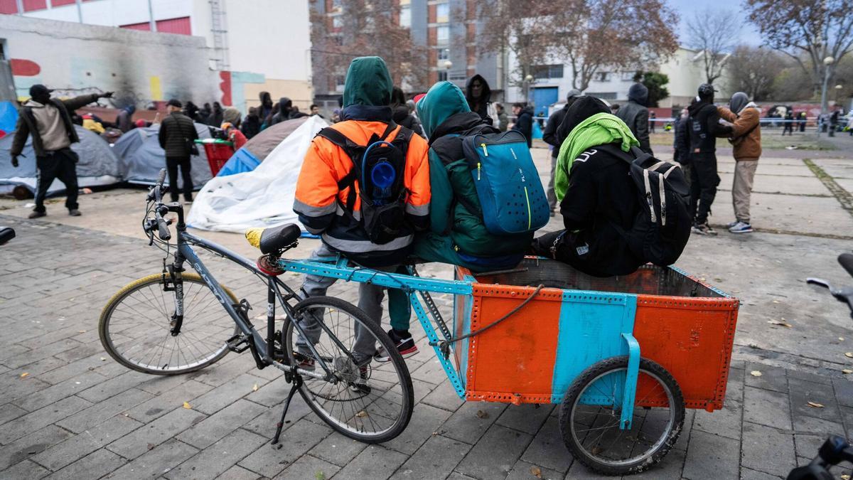 Personas desalojadas del B9 de Badalona se apoyan en uno de los carros que utilizan para recoger chatarra, dos días después de la desocupación