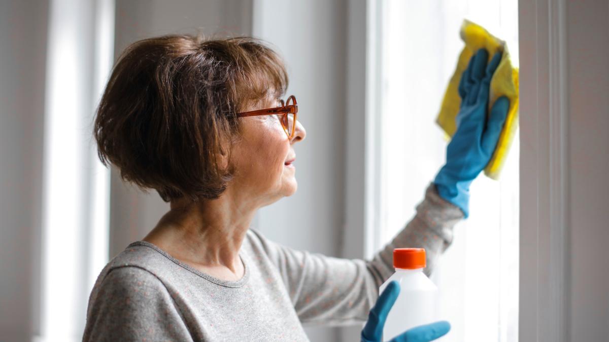 Una mujer limpiando la casa.