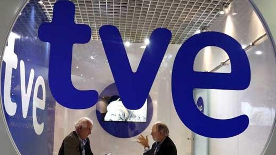 Dos visitantes conversan en el puesto de TVE.