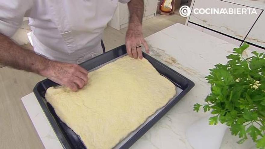 Karlos Arguiñano estirando la masa de pizza sobre una bandeja de horno