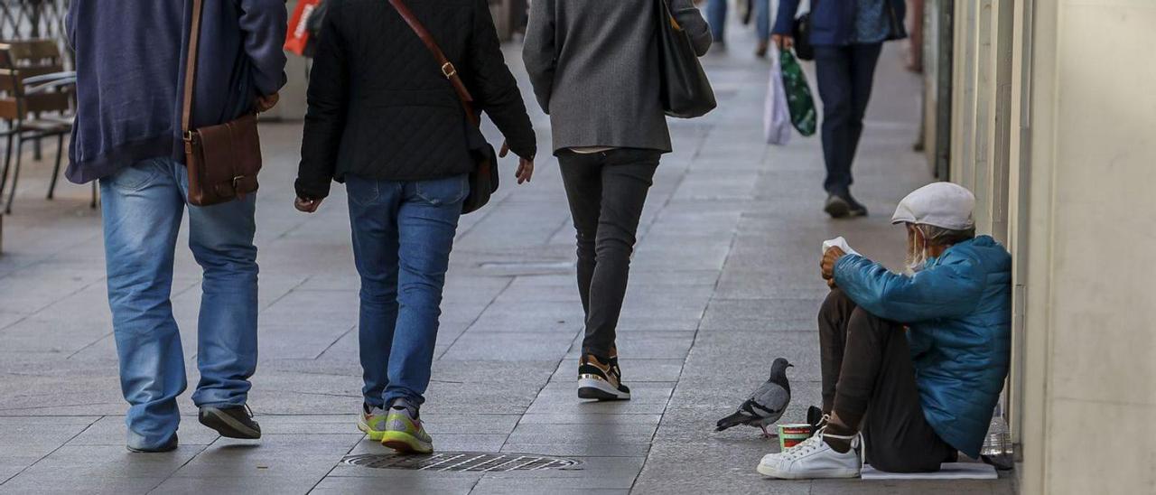 Un hombre pide ayuda económica en el centro de la ciudad, esta semana.  | HÉCTOR FUENTES