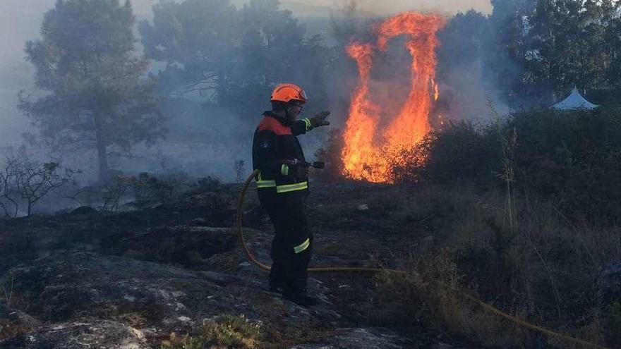 Miembros de Protección Civil Cangas en una de las zonas afectadas por el fuego. // S.Á.