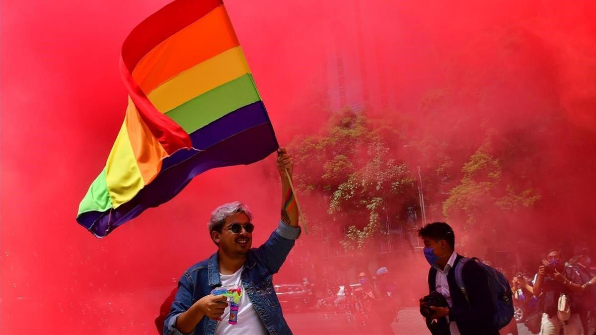 Decenas de personas de la comunidad LGBT marchan en Ciudad de México.