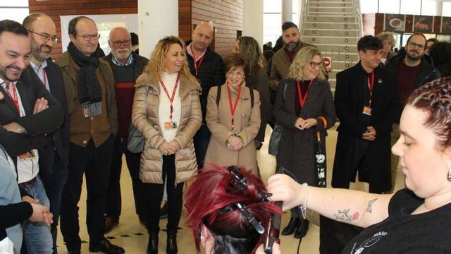 Una alumna del módulo de Peluquería trabaja ante los participantes en la visita institucional.  | A. VELASCO
