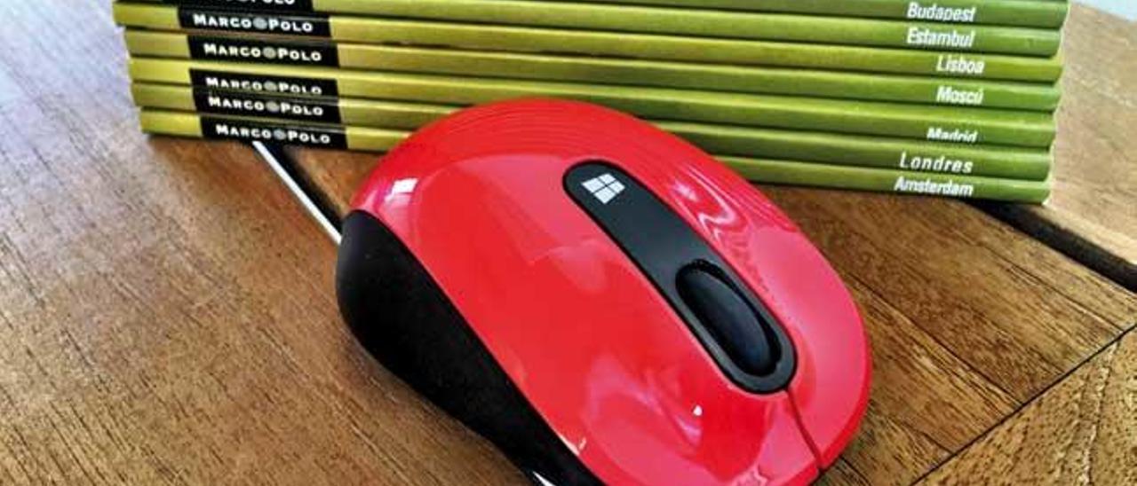El Sculpt Mobile Mouse está disponible en rojo, negro, rosa y azul. En la foto pequeña se ve la ranura en la que se aloja el adaptador inalámbrico.