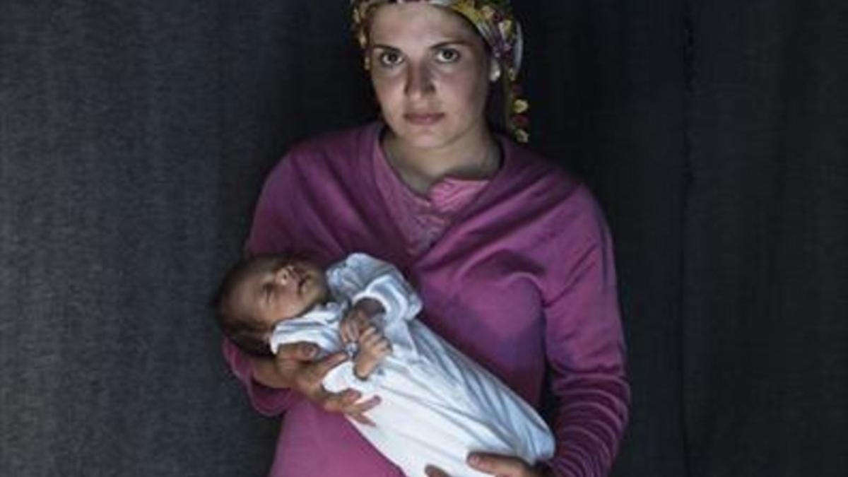 Una mujer kurda, con su hija, nacida en abril en Idomeni.