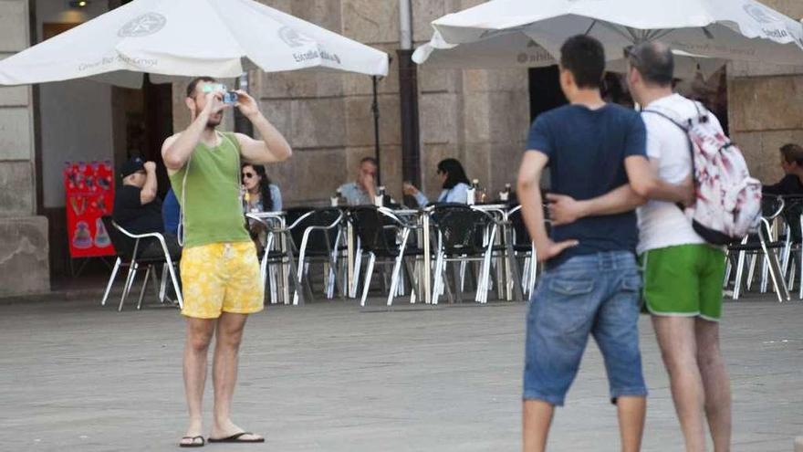 Tres turistas hacen fotografías en la ciudad.